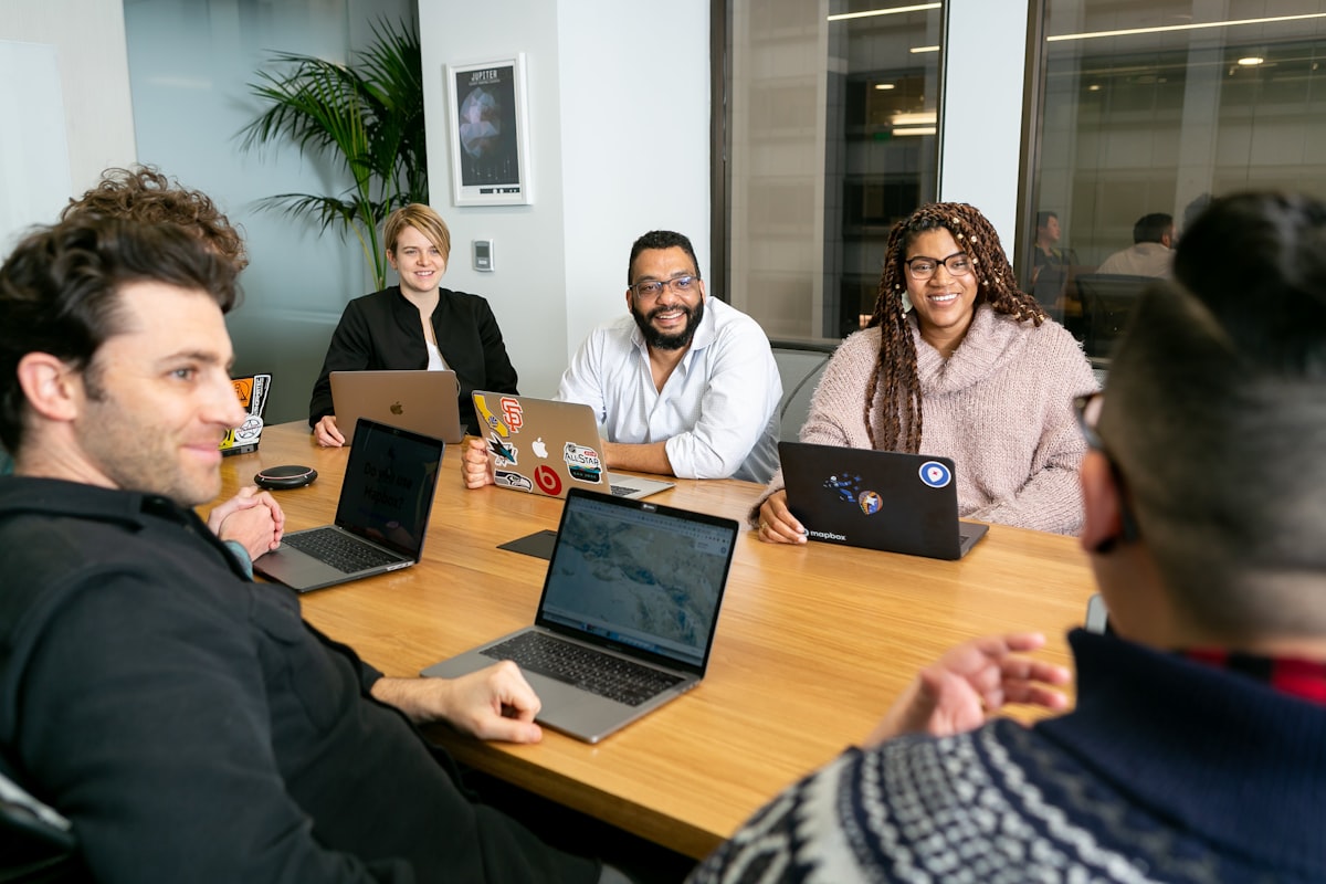 Analysts reviewing business data together on laptops